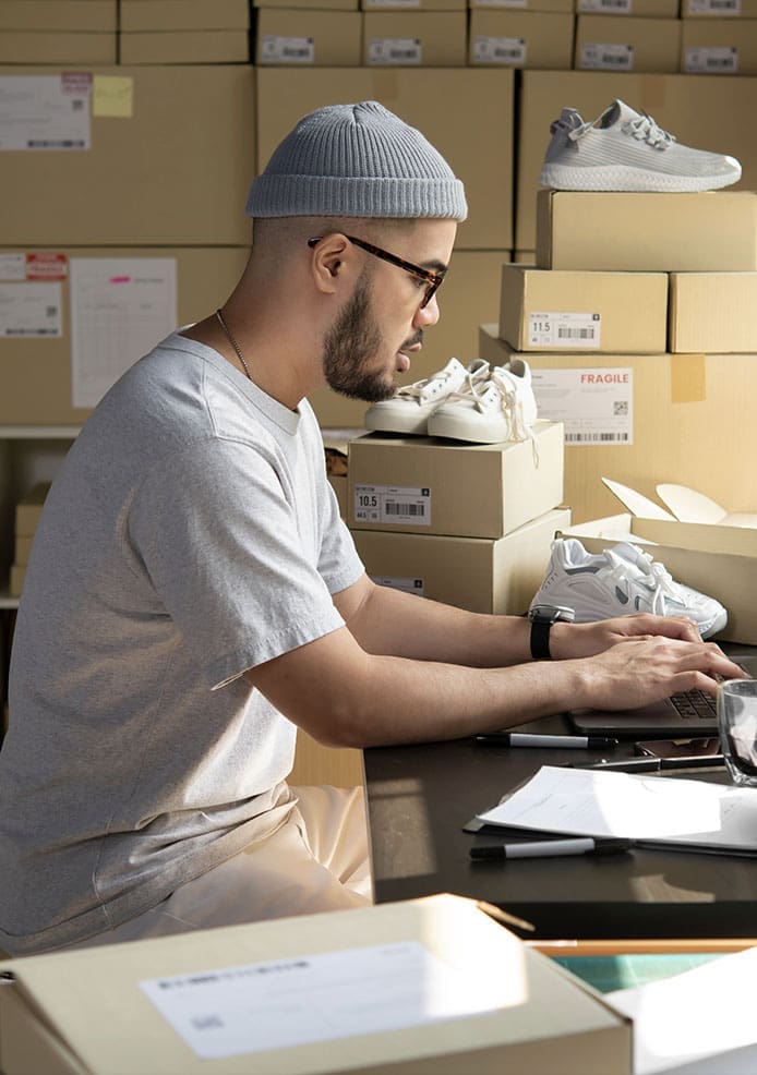 A man, freelancing as a web designer, is working on a laptop in a warehouse.